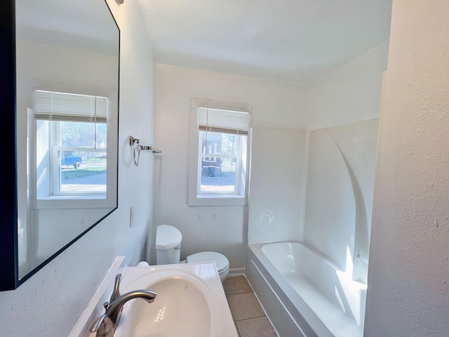 full bathroom featuring tile patterned floors, plenty of natural light, sink, and toilet