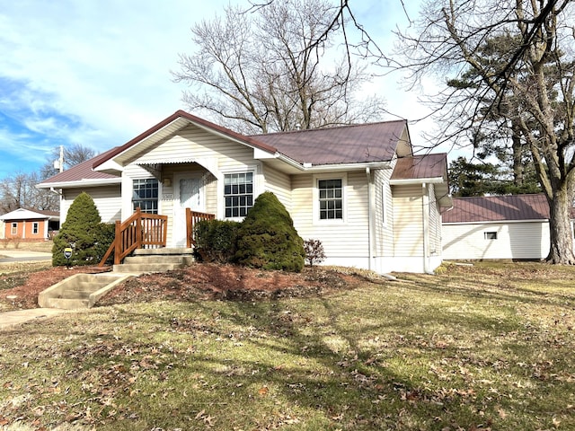 view of front facade featuring metal roof and a front lawn