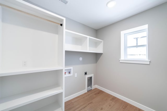 washroom with hookup for a washing machine, light hardwood / wood-style floors, and hookup for an electric dryer