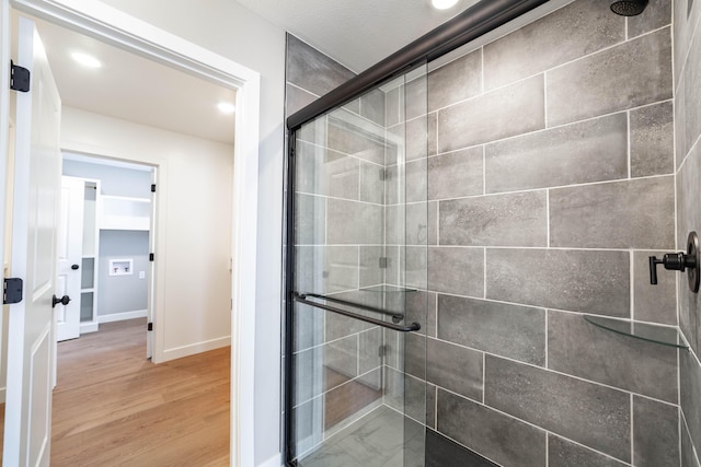 bathroom with wood-type flooring and an enclosed shower