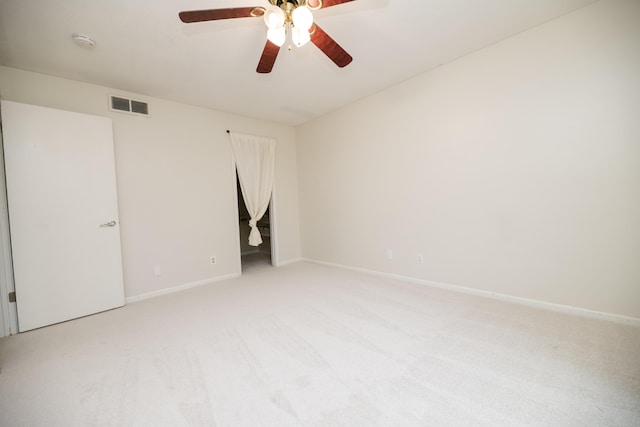 empty room with ceiling fan and light carpet