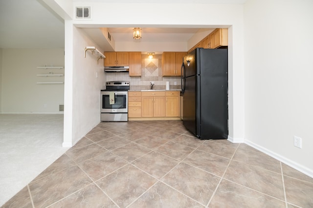 kitchen featuring black refrigerator, sink, tasteful backsplash, light tile patterned floors, and stainless steel electric stove