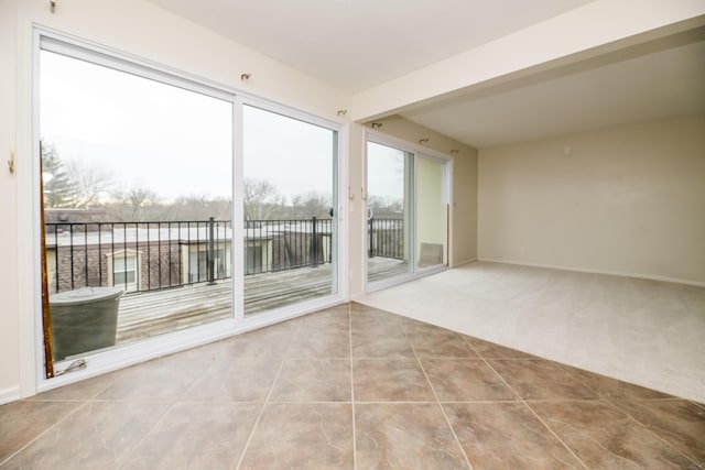 unfurnished room with a water view and tile patterned floors