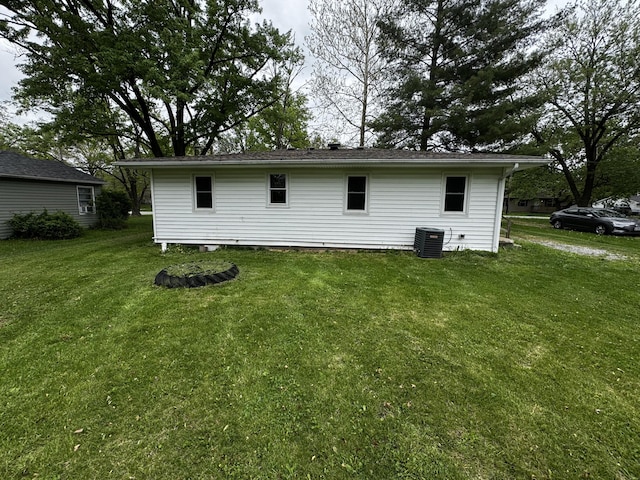 back of house featuring central AC and a yard