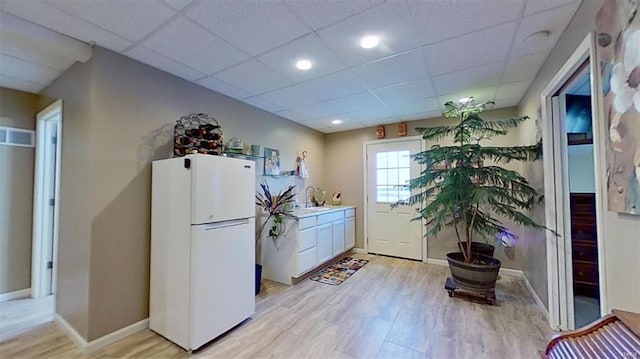 laundry room featuring sink and light hardwood / wood-style floors