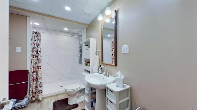 bathroom featuring sink, toilet, hardwood / wood-style flooring, and curtained shower