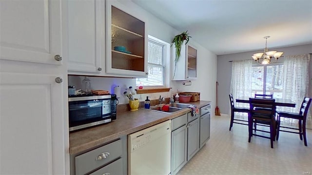 kitchen featuring white cabinets, pendant lighting, white dishwasher, and sink