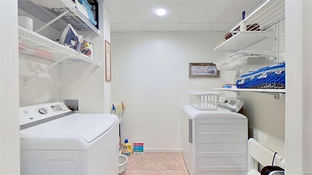 laundry area with washing machine and clothes dryer and light tile patterned floors