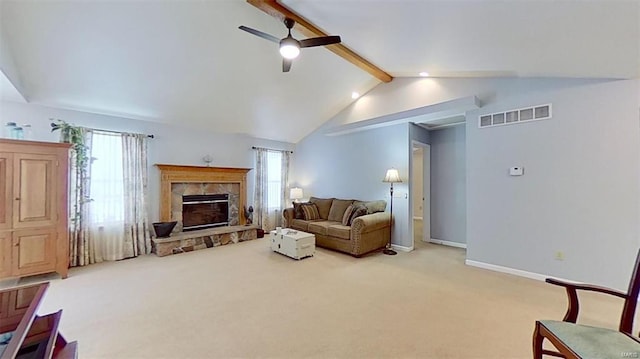 living room with ceiling fan, a stone fireplace, vaulted ceiling with beams, and carpet