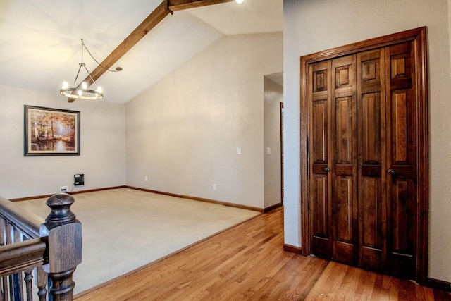 sitting room featuring lofted ceiling with beams, an inviting chandelier, baseboards, and light wood-style floors