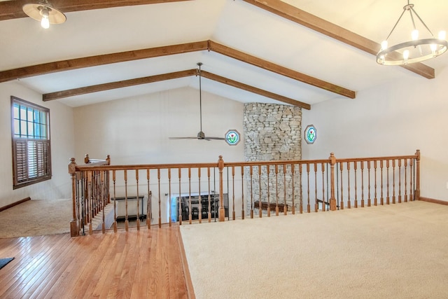 hall with a chandelier, lofted ceiling with beams, an upstairs landing, and wood finished floors