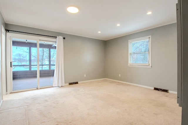 empty room featuring baseboards, visible vents, and light colored carpet