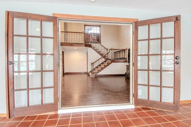 entryway featuring wood finished floors, baseboards, and stairs