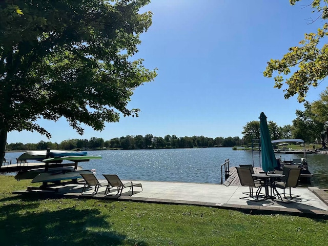 view of dock with a yard and a water view