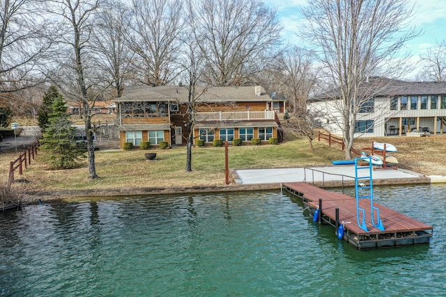 view of dock with a water view and a yard