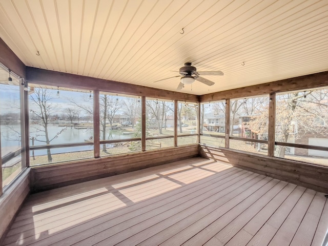 unfurnished sunroom with a water view and ceiling fan