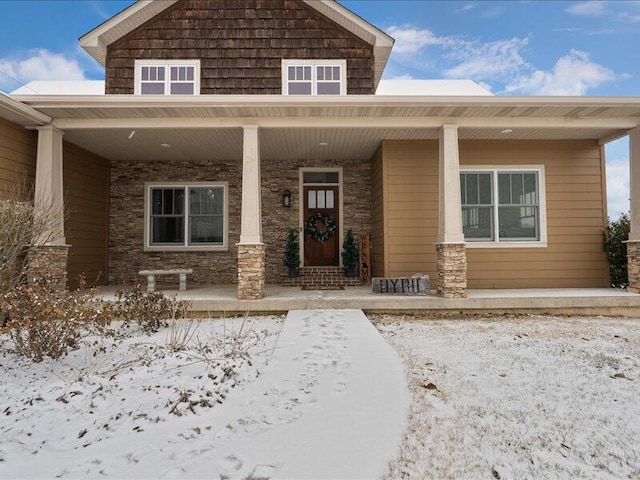 snow covered property entrance featuring a porch