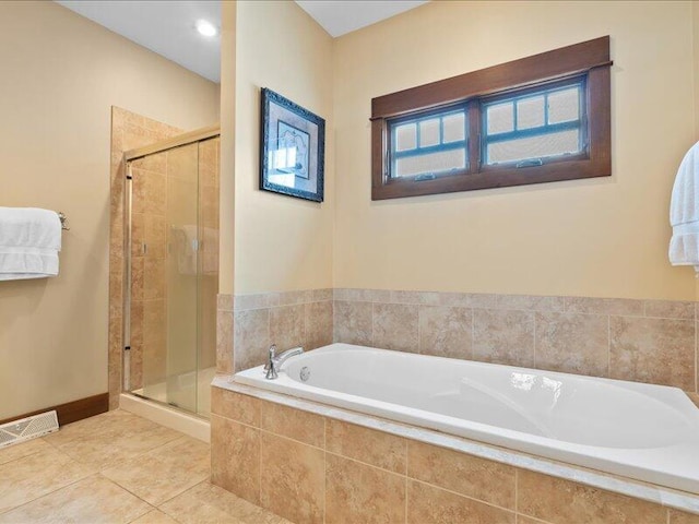 bathroom with tile patterned flooring, visible vents, baseboards, a bath, and a stall shower