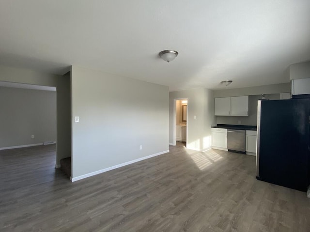 unfurnished living room featuring dark wood-style floors and baseboards