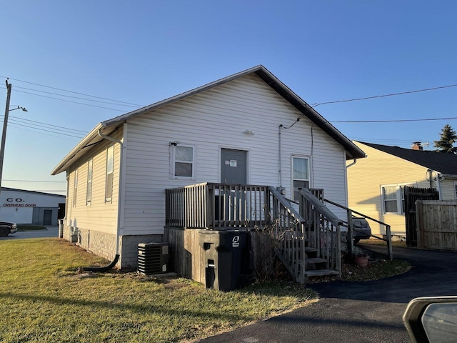 view of front of property with a front yard and central air condition unit