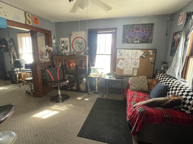 living room with a wealth of natural light, carpet flooring, and ceiling fan