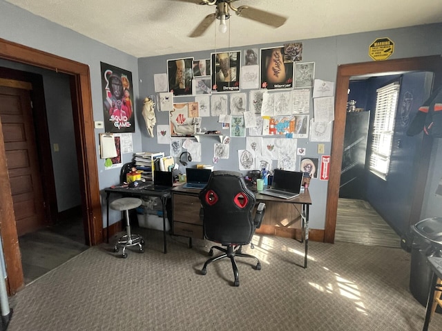 carpeted office space featuring a ceiling fan