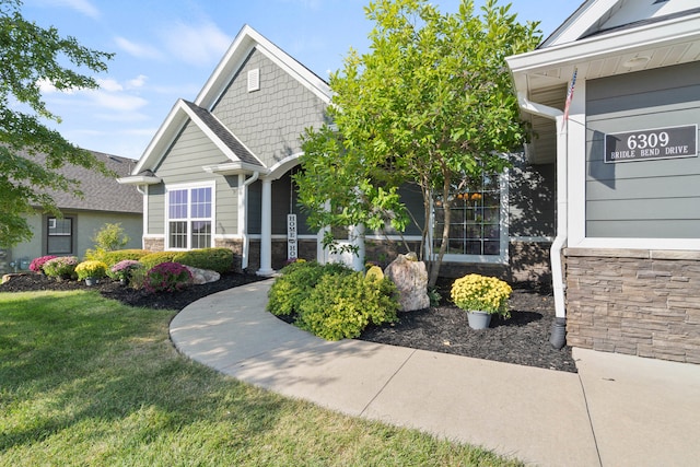 view of front of home featuring stone siding and a front lawn