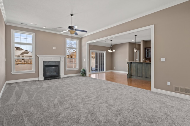 unfurnished living room with a fireplace, visible vents, carpet flooring, and ornamental molding