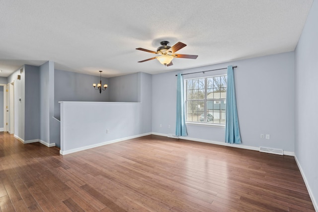 spare room featuring baseboards, visible vents, and wood finished floors