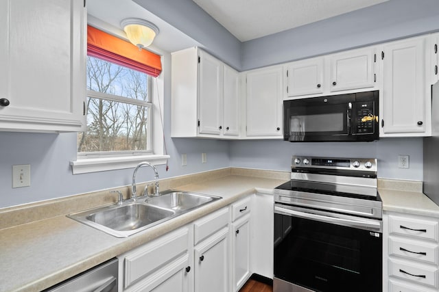 kitchen featuring white cabinetry, appliances with stainless steel finishes, light countertops, and a sink