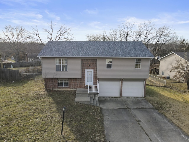 split foyer home with brick siding, a shingled roof, concrete driveway, fence, and a garage