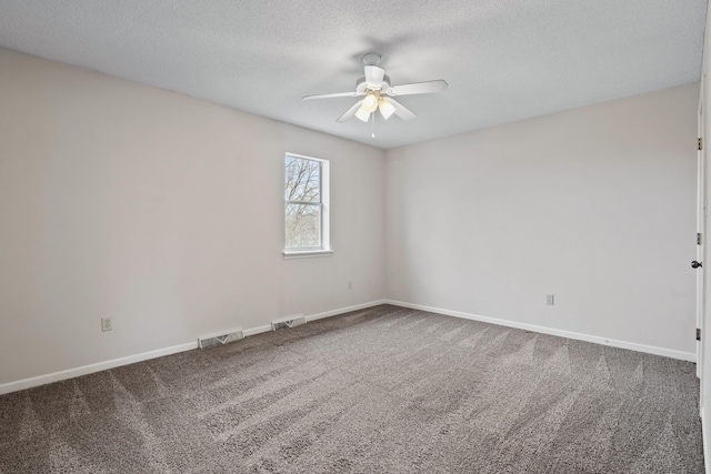 carpeted spare room with visible vents, a textured ceiling, and baseboards