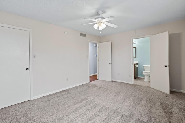 unfurnished bedroom featuring carpet floors, visible vents, baseboards, and ensuite bathroom