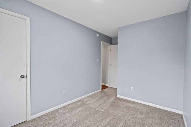 carpeted spare room with baseboards