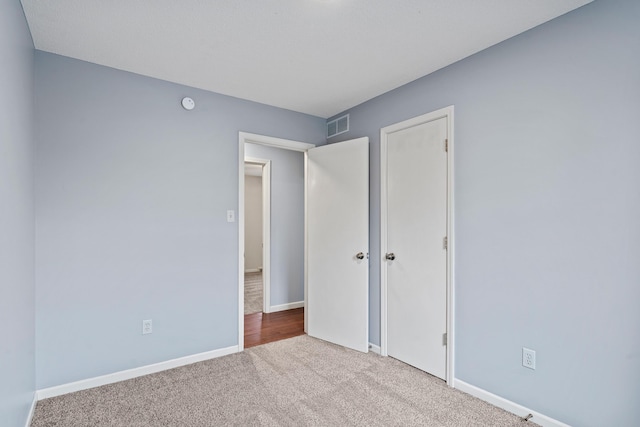 unfurnished bedroom featuring carpet, visible vents, baseboards, and a closet