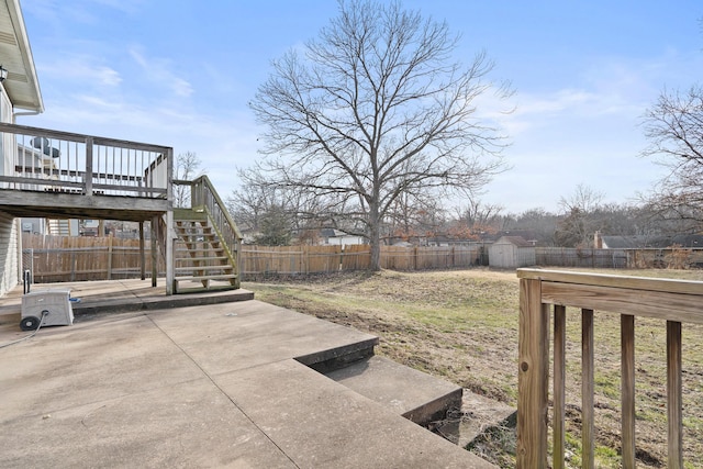 view of yard with an outbuilding, a patio, stairway, a deck, and a fenced backyard