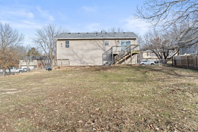 back of house featuring a wooden deck, stairs, fence, and a yard