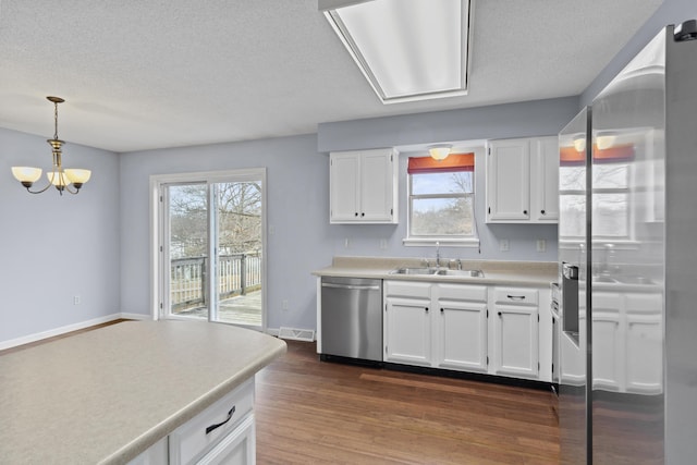 kitchen with light countertops, dark wood-type flooring, white cabinetry, a sink, and dishwasher