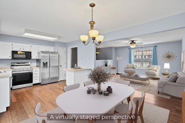 dining space featuring light wood-style floors, baseboards, and ceiling fan with notable chandelier