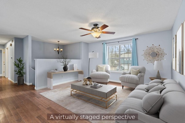 living room with a textured ceiling, ceiling fan with notable chandelier, wood finished floors, and baseboards