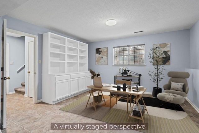 office featuring a textured ceiling, visible vents, and baseboards