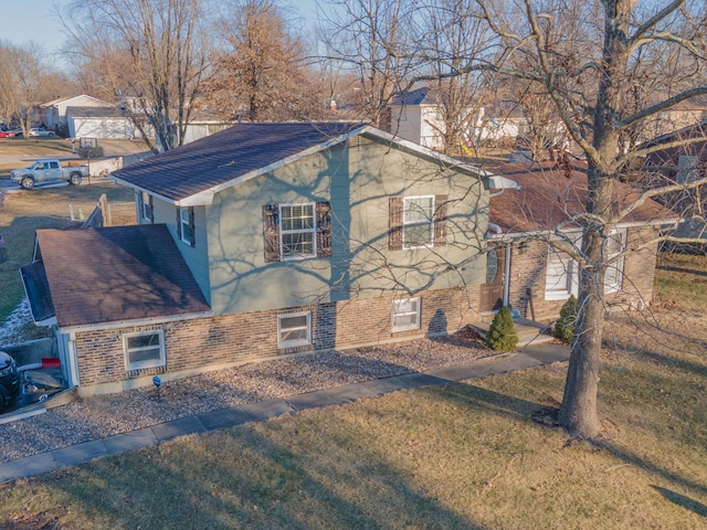 view of side of home with a yard, brick siding, and a chimney