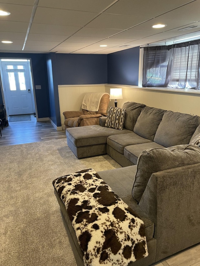 living room with a drop ceiling, wainscoting, and wood finished floors