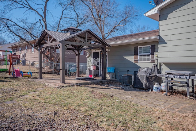 exterior space with a gazebo, central AC unit, a front yard, and fence