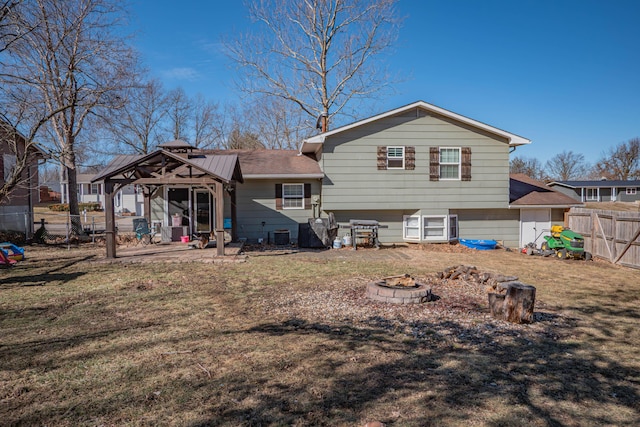 rear view of house with a patio, a fire pit, a yard, and fence