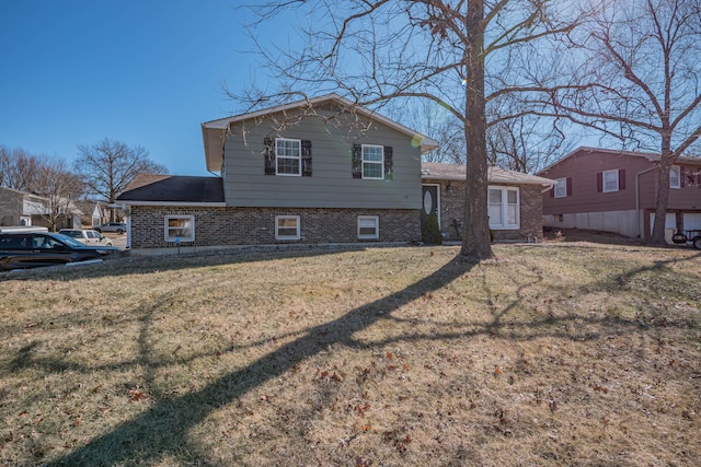 back of house featuring a yard and brick siding