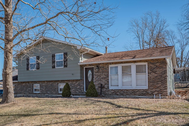 tri-level home featuring brick siding and a front yard