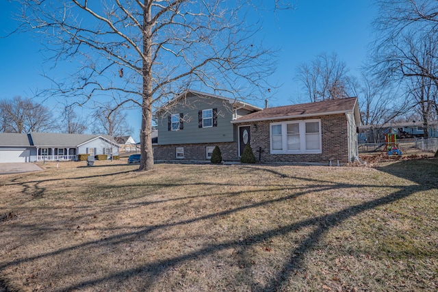 tri-level home featuring brick siding and a front yard