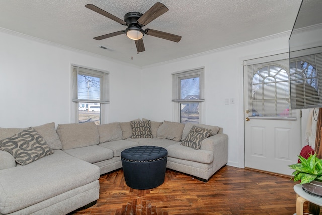 living room with crown molding, visible vents, a ceiling fan, a textured ceiling, and wood finished floors