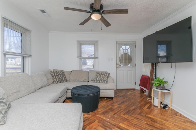 living area featuring a textured ceiling, ornamental molding, visible vents, and a ceiling fan